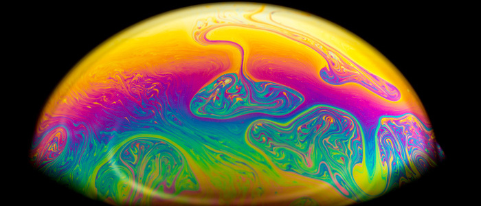 Macro picture of half soap bubble on black background. psychedelic color for a wallpaper or screensaver