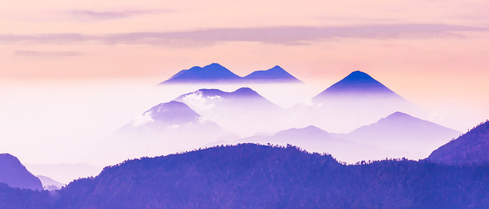 Peaceful image of calm landscape with blue mountains and pale sky